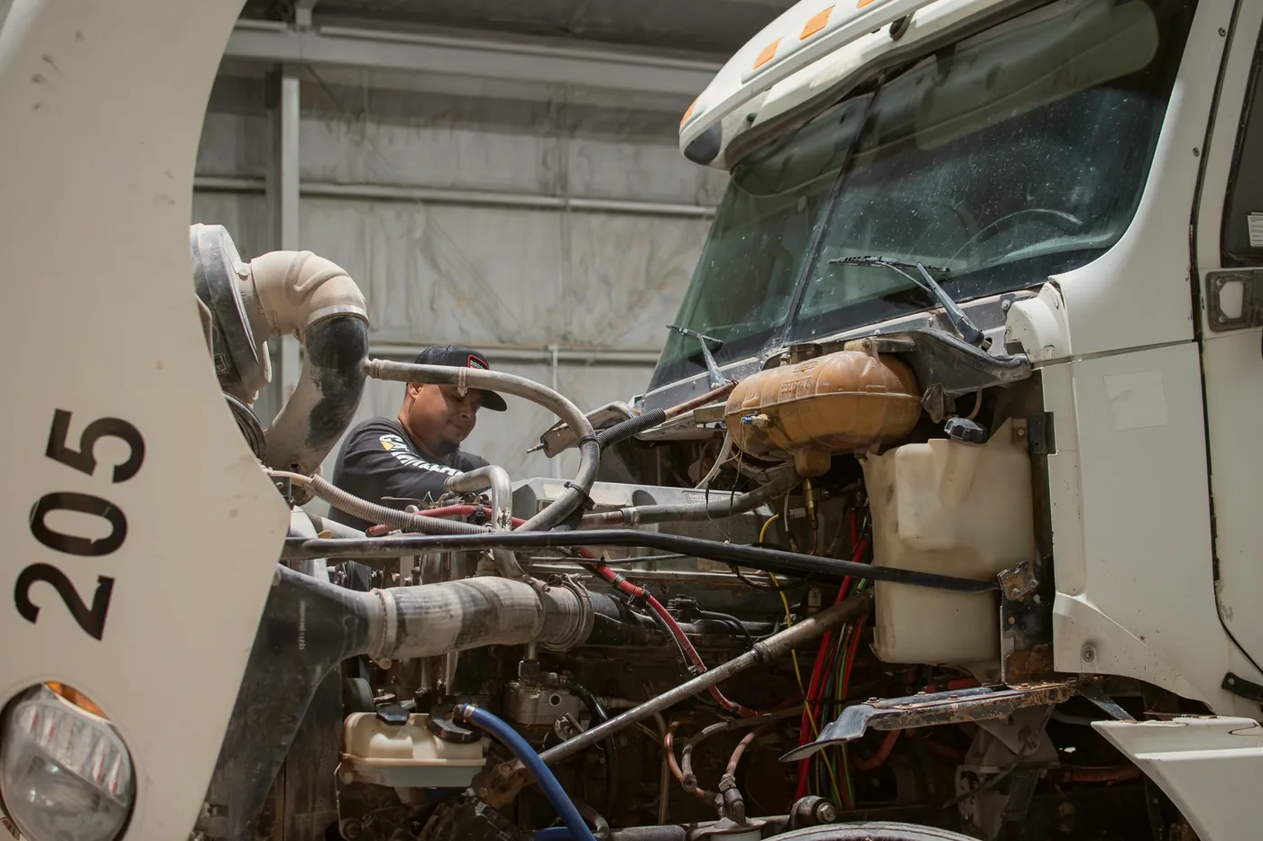 A Sarge mechanic working on the engine of truck 205 in the shop